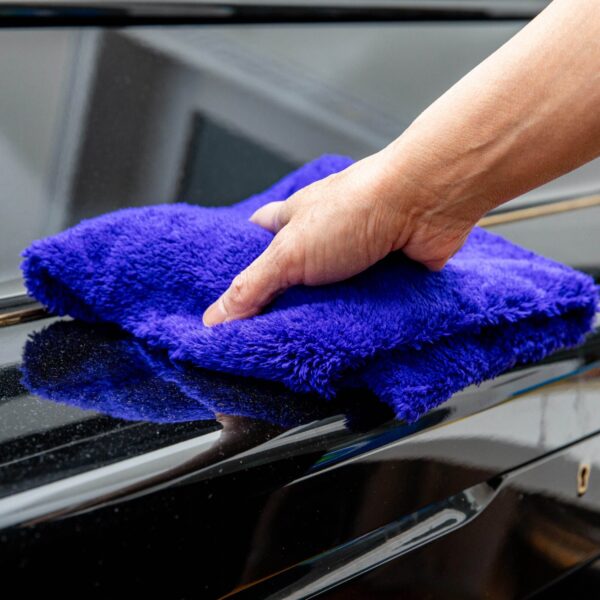 Plush Purple microfiber cloth dusting a piano surface.