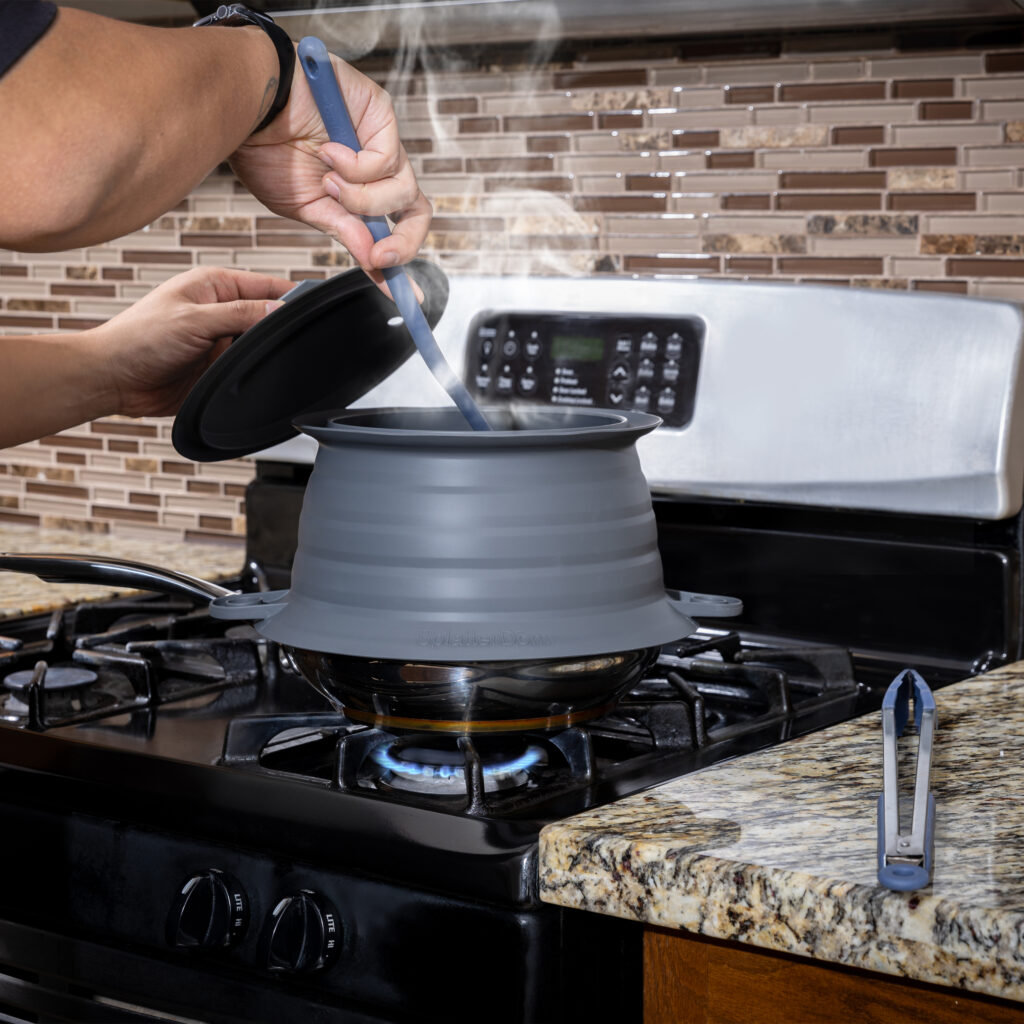 Chic Metallic SplatterDōm on pan with Bold Blue utensils being used beside it on granite countertop.